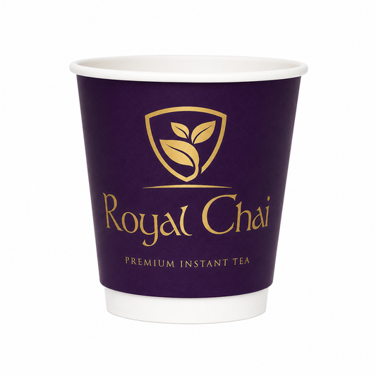 A disposable paper coffee cup with a deep purple body, white rim and base, featuring a gold shield logo with leaves and the text 'Royal Chai' and 'PREMIUM INSTANT TEA'.